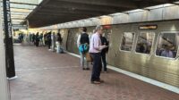 People standing on platform to board Metro train.