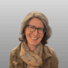 Headshot of woman wearing glasses, decorative scarf and jacket